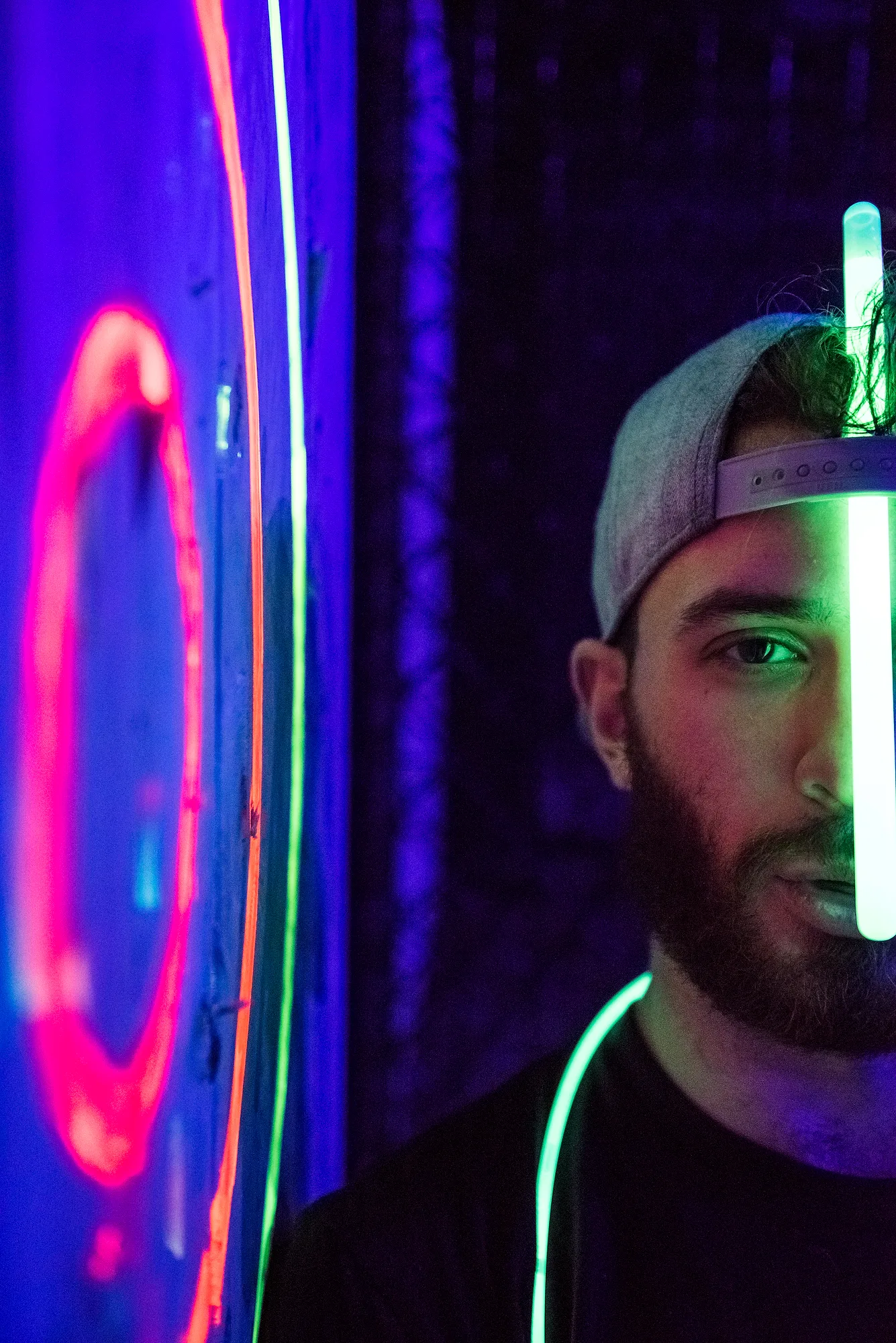 Axe thrower lit by neon at the throwing lanes