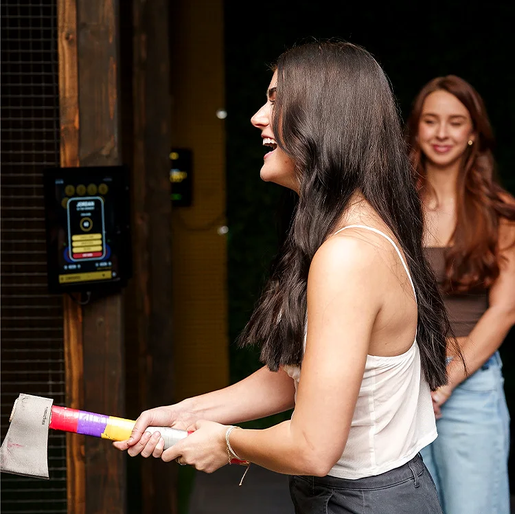 Guest laughing while holding a colorful axe